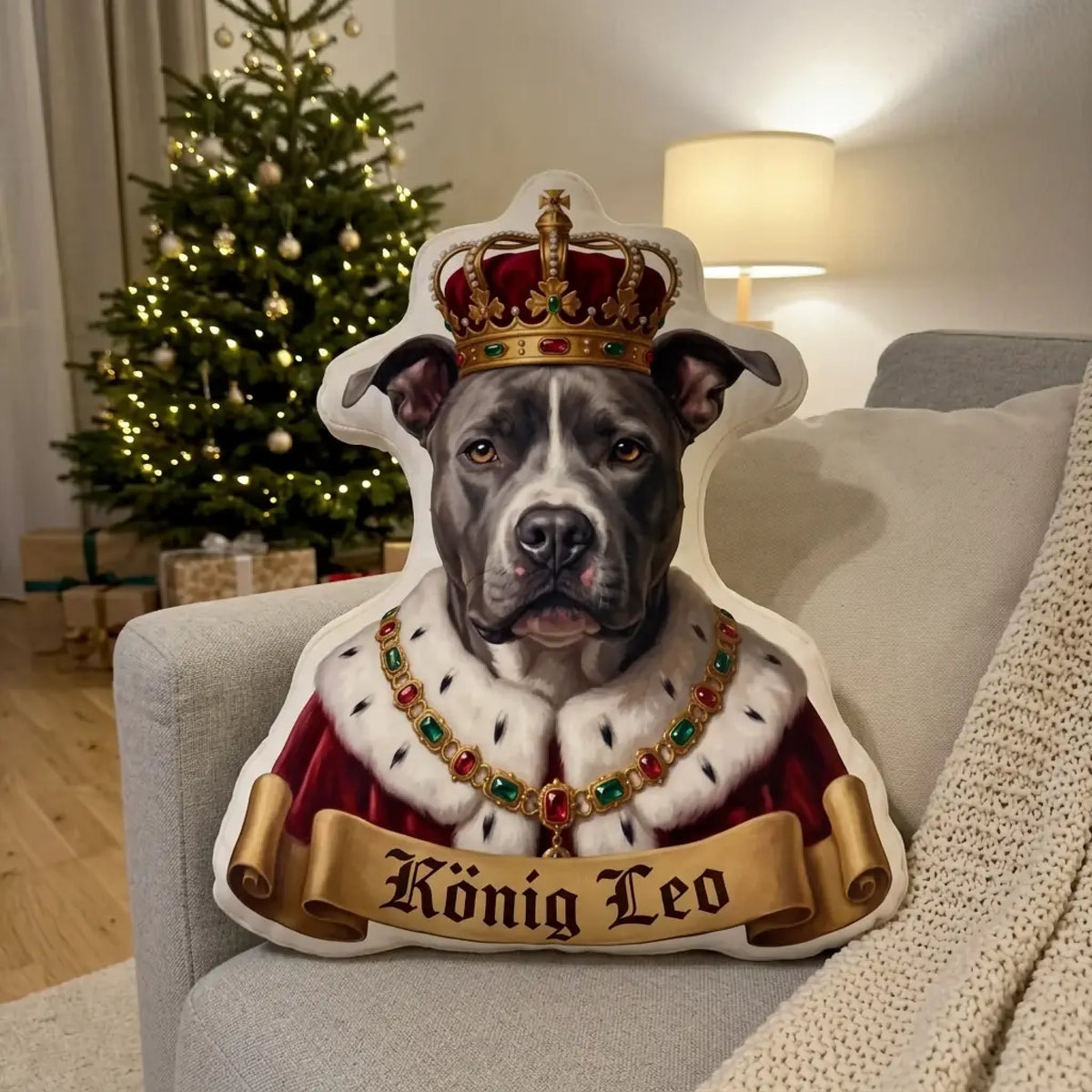 Hundeportrait als König mit Krone und Hermelinmantel als Formkissen auf dem Sofa vor dem Weihnachtsbaum