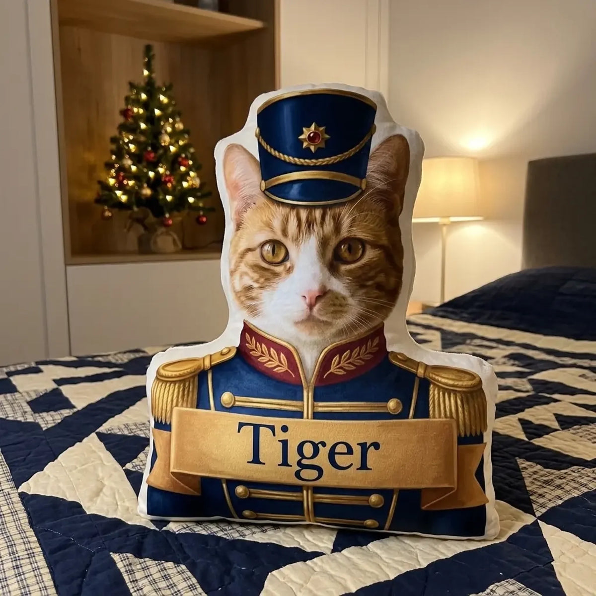 Personalisiertes Kissen Katze als Nussknacker in blauer Uniform auf dem Bett vor dem Weihnachtsbaum
